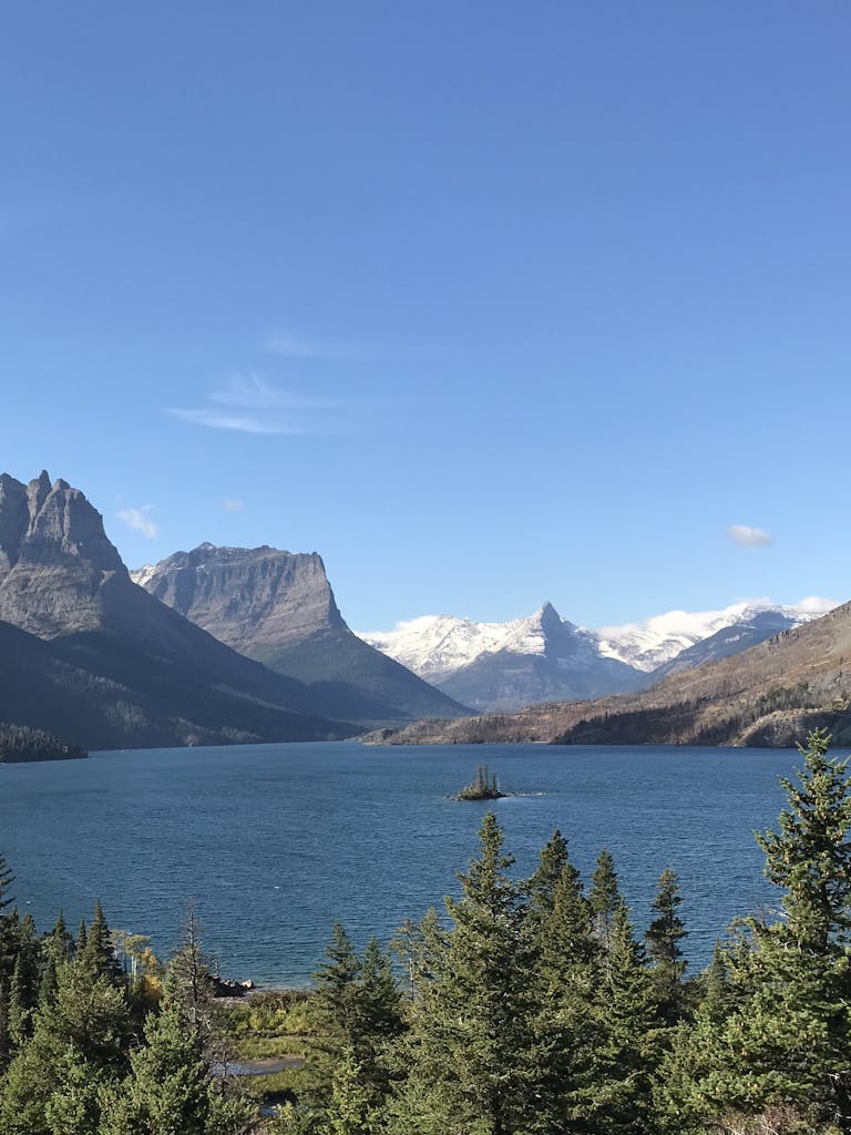 Breathtaking view of St. Mary Lake in Glacier National Park with snow-capped mountains and clear blue skies.
